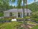 Charming home featuring a manicured front yard with lush landscaping and a welcoming entrance with stately columns at 8711 Crescent Forest Blvd, New Port Richey, FL 34654