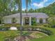 Charming home featuring a manicured front yard with lush landscaping and a welcoming entrance with stately columns at 8711 Crescent Forest Blvd, New Port Richey, FL 34654