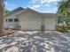 Exterior shot of the attached three car garage showcasing its doors and design at 8711 Crescent Forest Blvd, New Port Richey, FL 34654