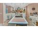 Open-concept kitchen with an island cooktop, stainless steel sink, and seamless flow into the living area, perfect for entertaining at 8711 Crescent Forest Blvd, New Port Richey, FL 34654