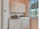 Practical laundry room featuring front load washer and dryer set and storage cabinets for organization at 8711 Crescent Forest Blvd, New Port Richey, FL 34654