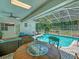Relaxing screened-in pool area with outdoor dining set, comfortable seating, and direct access to the backyard at 8711 Crescent Forest Blvd, New Port Richey, FL 34654