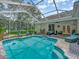Stunning screened-in pool and patio, surrounded by lush landscaping providing a private outdoor oasis at 8711 Crescent Forest Blvd, New Port Richey, FL 34654