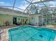 Beautiful screened-in pool featuring a spacious patio area with dining and lounge seating, ideal for entertaining at 8711 Crescent Forest Blvd, New Port Richey, FL 34654