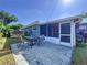 Backyard with a screened porch and outdoor seating on a paved patio surrounded by lush greenery at 8848 56Th N Way, Pinellas Park, FL 33782