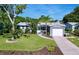 Charming home showcasing a lush front yard with mature landscaping, a one car garage, and inviting entrance at 8848 56Th N Way, Pinellas Park, FL 33782