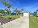 Home exterior with manicured lawn, mature landscaping, and driveway leading to attached garage at 8848 56Th N Way, Pinellas Park, FL 33782
