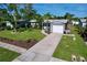 Single story home featuring a long driveway, a well maintained lawn, mature trees, and an attached one-car garage at 8848 56Th N Way, Pinellas Park, FL 33782