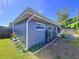 Exterior view of a grey block house with a screened porch, green grass, and manicured garden beds at 8848 56Th N Way, Pinellas Park, FL 33782