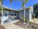 Charming home exterior with a welcoming front porch, seating, and beautiful landscaping at 8848 56Th N Way, Pinellas Park, FL 33782