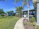 Inviting home exterior featuring lush green lawn, mature trees, and a curved walkway to the front door at 8848 56Th N Way, Pinellas Park, FL 33782