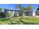 Well-maintained home exterior with green lawn, mature trees, and a cozy front porch at 8848 56Th N Way, Pinellas Park, FL 33782