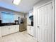 Updated kitchen with white cabinets, stainless steel refrigerator, sink, and black subway tile backsplash at 8848 56Th N Way, Pinellas Park, FL 33782