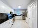 Bright kitchen with white cabinets, stainless steel appliances, black countertops and subway tile, with a refrigerator at 8848 56Th N Way, Pinellas Park, FL 33782