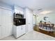 Modern kitchen with white cabinets, stainless steel microwave, and open view into the dining and living areas at 8848 56Th N Way, Pinellas Park, FL 33782