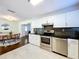 Well-lit kitchen featuring stainless steel appliances, a black backsplash, tile flooring, and an open concept dining area at 8848 56Th N Way, Pinellas Park, FL 33782