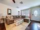 Comfortable living room featuring a sectional sofa, hardwood floors, an accent rug, and a front door at 8848 56Th N Way, Pinellas Park, FL 33782