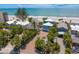 Wonderful aerial view of a community of beachfront homes surrounded by palms trees with the ocean nearby at 20060 Gulf Blvd, Indian Shores, FL 33785