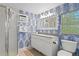 Bright bathroom featuring modern fixtures, striking patterned wallpaper, and a sleek vanity with ample storage at 20060 Gulf Blvd, Indian Shores, FL 33785