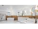 Bright bathroom features a standalone tub beneath a modern chandelier and dual sink vanity at 20060 Gulf Blvd, Indian Shores, FL 33785
