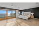 Bright bedroom features a waterfront view, dark accent wall, and light wood flooring at 20060 Gulf Blvd, Indian Shores, FL 33785