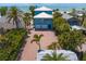 Charming blue beach house boasting a metal roof, an inviting front porch, and a spacious two-car garage at 20060 Gulf Blvd, Indian Shores, FL 33785