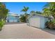 Charming blue house with a two-car garage and an additional single-car garage, surrounded by lush greenery at 20060 Gulf Blvd, Indian Shores, FL 33785