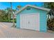 Detached garage with white double doors, nestled in a lush, tropical landscape at 20060 Gulf Blvd, Indian Shores, FL 33785