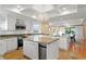 Open-concept kitchen with a large island, granite countertops, stainless appliances, and white cabinetry overlooks the dining area at 20060 Gulf Blvd, Indian Shores, FL 33785