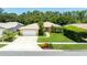 Aerial view of a well-kept home with a green lawn, landscaping, and a driveway at 11116 118Th St, Seminole, FL 33778