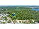 An aerial view of a community with a pond and green trees surrounding residential houses at 11116 118Th St, Seminole, FL 33778