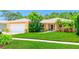 Beautiful home featuring a lush lawn, palm trees, and a charming walkway leading to the front door at 11116 118Th St, Seminole, FL 33778
