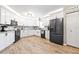 Modern kitchen with white cabinets, stainless steel appliances, and stylish backsplash, and wood-look floors at 11116 118Th St, Seminole, FL 33778