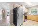 Kitchen featuring wood cabinetry, tile flooring, a stainless steel refrigerator, and doorway to living room at 11116 118Th St, Seminole, FL 33778