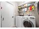 Functional laundry room with modern washer and dryer, shelving and door to another room at 11116 118Th St, Seminole, FL 33778