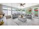 Bright sunroom featuring a large sectional sofa, ceiling fan, and sliding glass doors to backyard at 11116 118Th St, Seminole, FL 33778