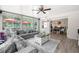 Bright sunroom featuring a large sectional sofa, ceiling fan, and entryway to dining area at 11116 118Th St, Seminole, FL 33778