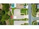 An overhead shot of a green lawn with spa, patio and red umbrellas between two houses at 11116 118Th St, Seminole, FL 33778