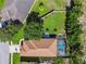 Aerial view of property featuring a screened-in pool, backyard fire pit and mature trees at 11125 Shelter Cove Loop, New Port Richey, FL 34654