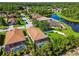 Aerial view of a home with screened pool, lush landscaping and lake view at 11125 Shelter Cove Loop, New Port Richey, FL 34654