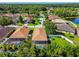 Aerial view of a home with screened pool, lush landscaping, and neighborhood at 11125 Shelter Cove Loop, New Port Richey, FL 34654