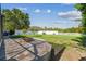 Backyard with paved patio, fire pit, lush lawn, and white picket fence at 11125 Shelter Cove Loop, New Port Richey, FL 34654