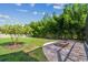 Spacious backyard featuring a paver patio, fire pit, and lush landscaping at 11125 Shelter Cove Loop, New Port Richey, FL 34654