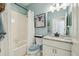 Stylishly renovated bathroom with white vanity, bathtub, and light blue accent wall at 11125 Shelter Cove Loop, New Port Richey, FL 34654