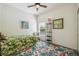 Bright guest bedroom featuring a tropical-patterned bed, chair, and rug at 11125 Shelter Cove Loop, New Port Richey, FL 34654