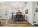 Bright dining room with luxury vinyl plank flooring, a modern chandelier, and ample natural light at 11125 Shelter Cove Loop, New Port Richey, FL 34654