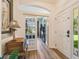 Welcoming entryway featuring wood look floors, an arched entry into the office, and a front door with side window at 11125 Shelter Cove Loop, New Port Richey, FL 34654