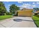 Yellow home with a two-car garage and landscaped front yard, under a sunny sky at 11125 Shelter Cove Loop, New Port Richey, FL 34654