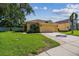 Charming single-Gathering home with a lush green lawn, mature trees, and a two-car garage at 11125 Shelter Cove Loop, New Port Richey, FL 34654