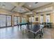 Bright community game room featuring a pool table, ping pong, foosball and comfortable seating at 11125 Shelter Cove Loop, New Port Richey, FL 34654